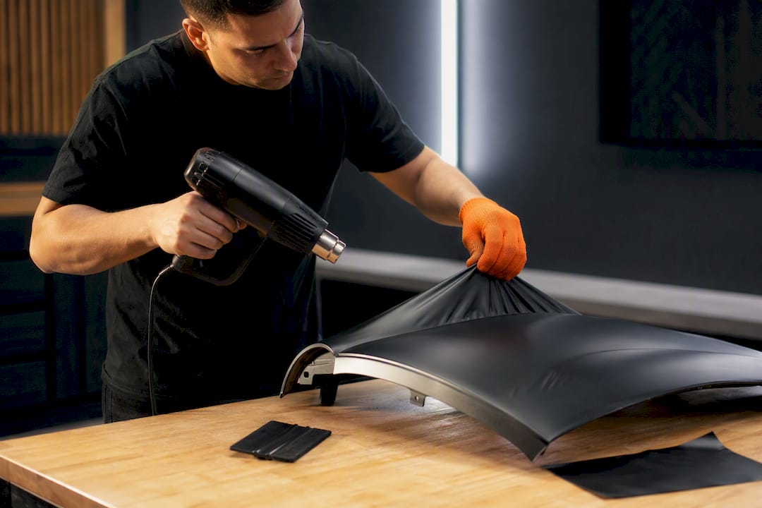 Technician practicing vinyl heating on scrap panel