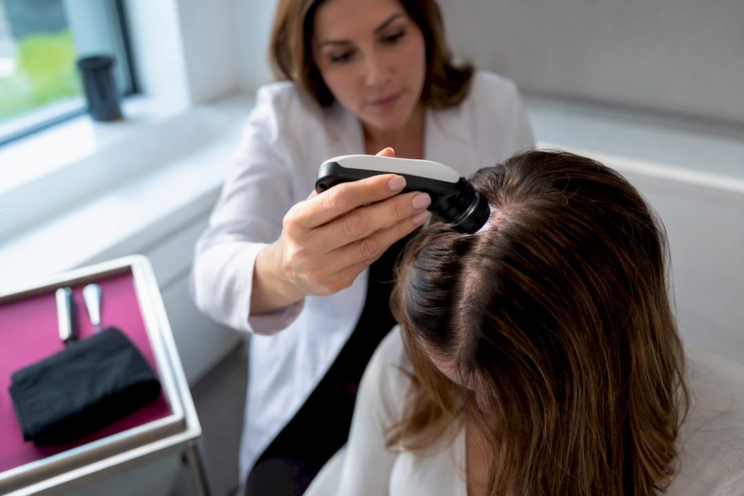 Dermatologist examining a woman’s scalp