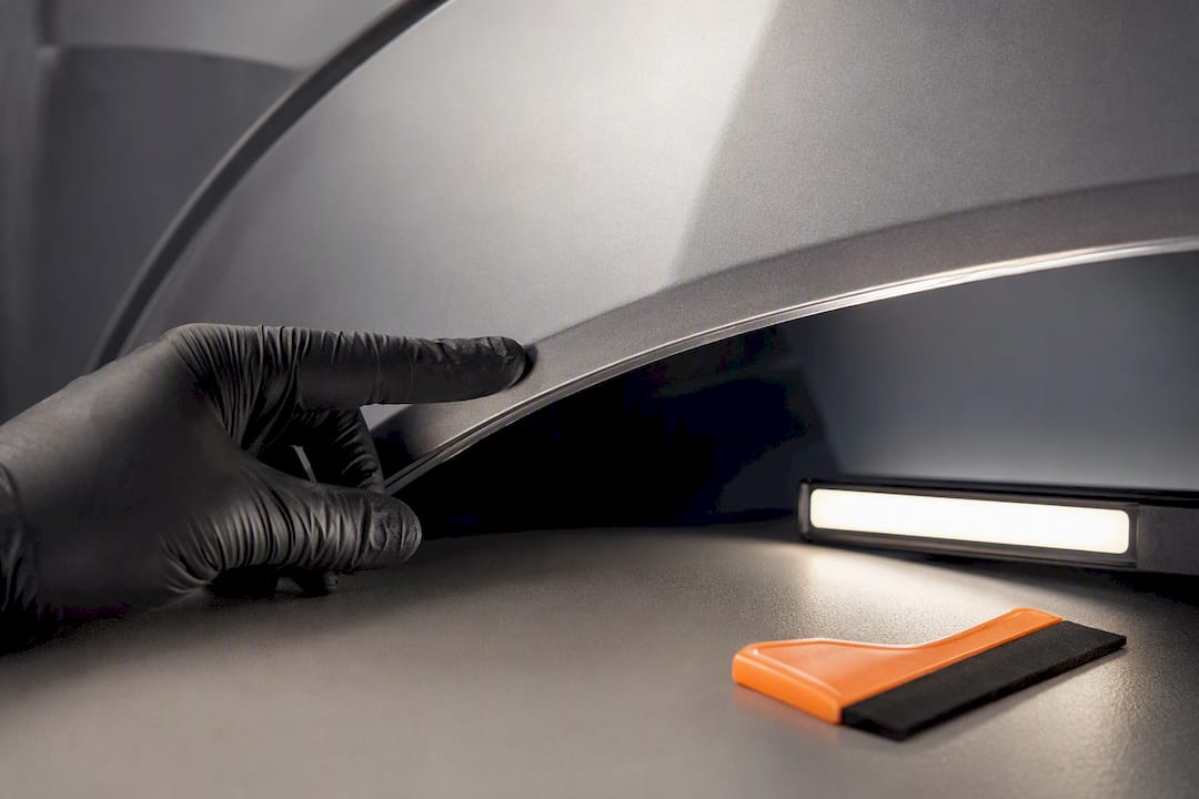 Installer checking a tucked PPF edge