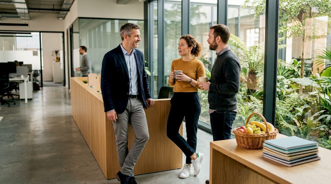 Le manager et son équipe échangent autour de la machine à café pendant la pause.