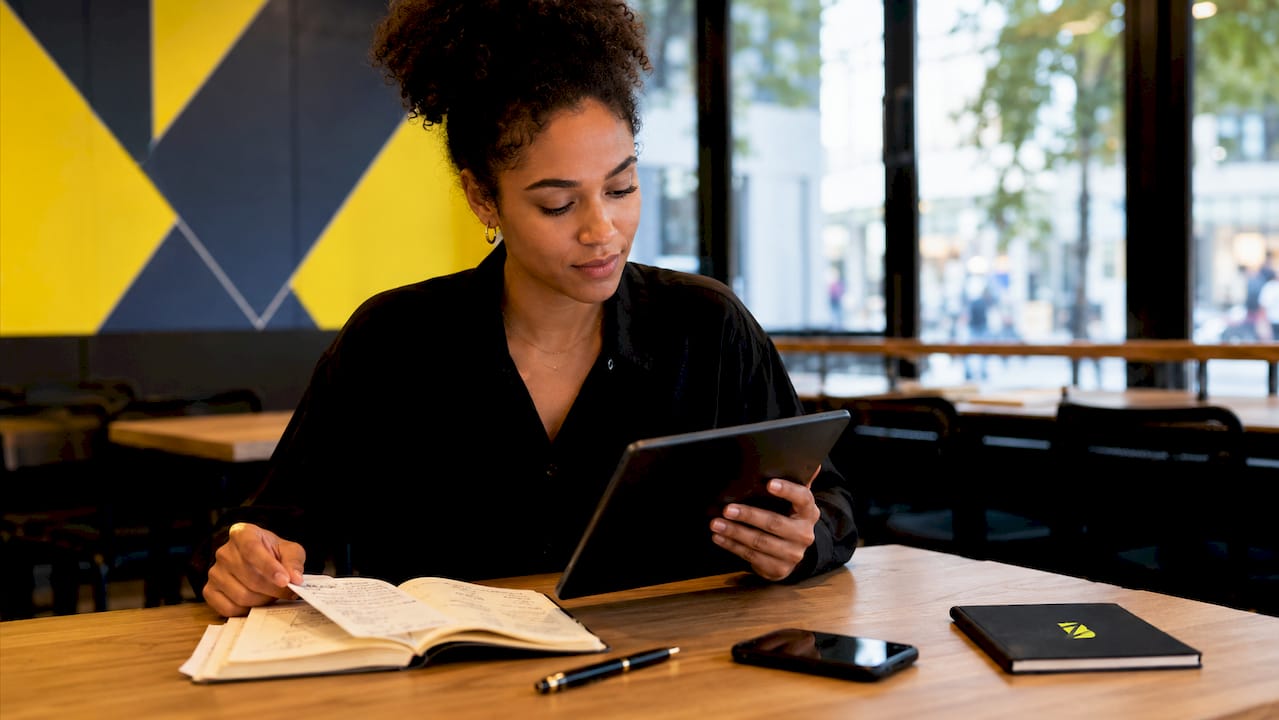 Des mains tiennent une tablette pour analyser le parcours client