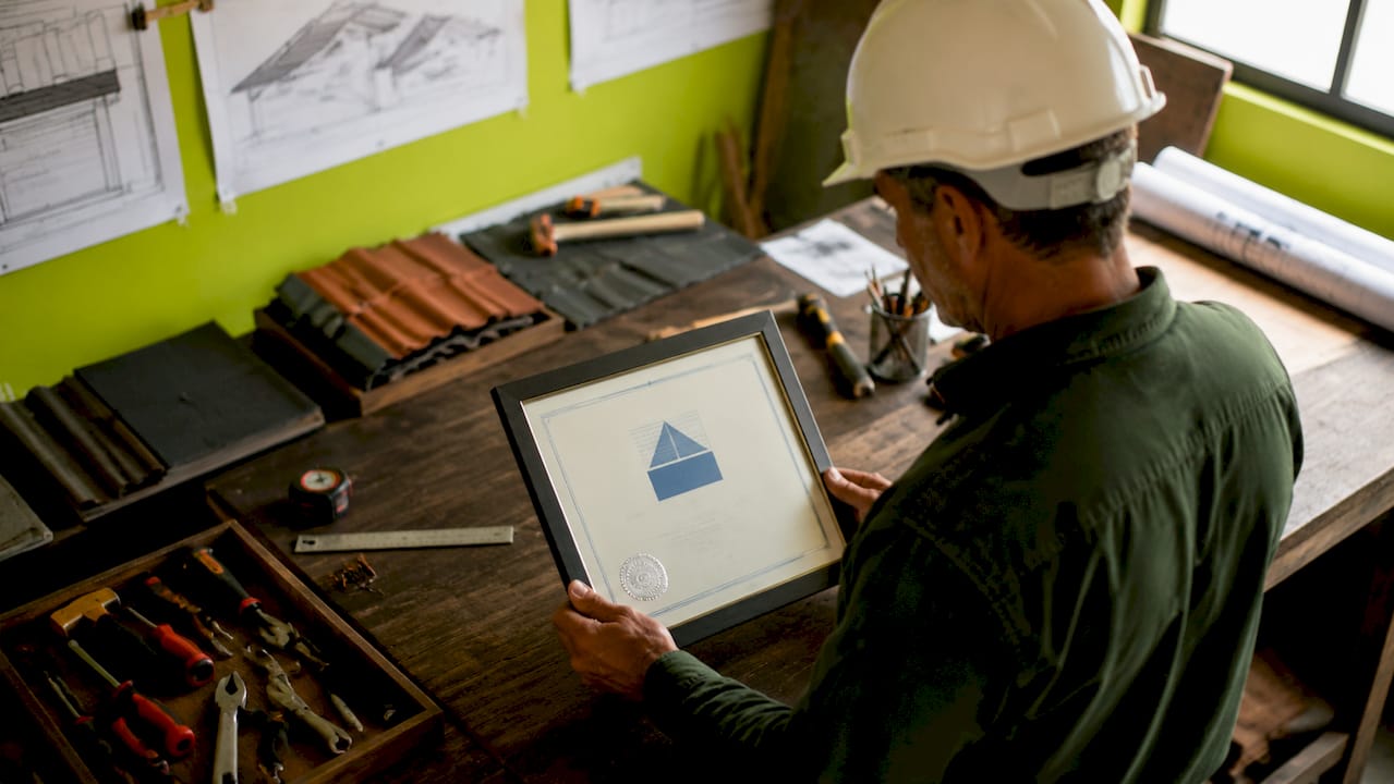 Un artisan fier présente son certificat RGE Qualibat entre ses mains expertes.