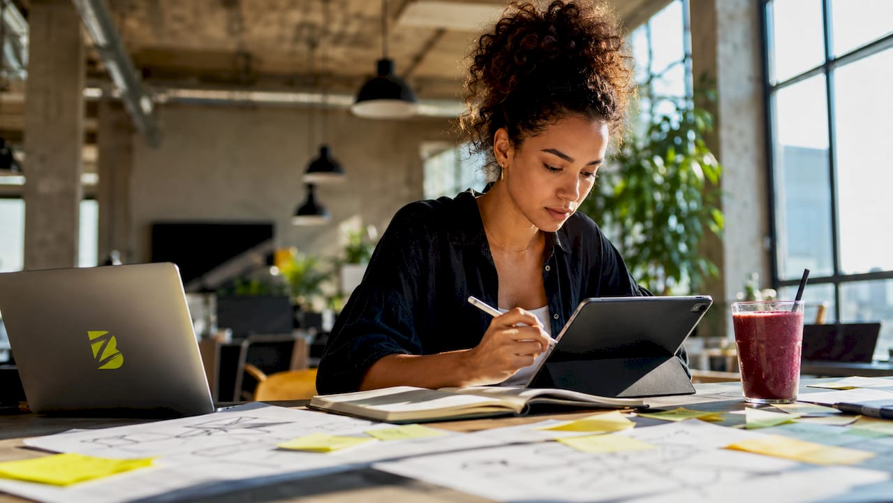 Jeune femme concentrée sur sa tablette, en pleine création de stratégies de design.