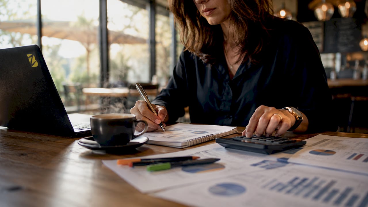 Une femme analyse le retour sur investissement sur son ordinateur, dans un bureau à la pointe de la modernité.