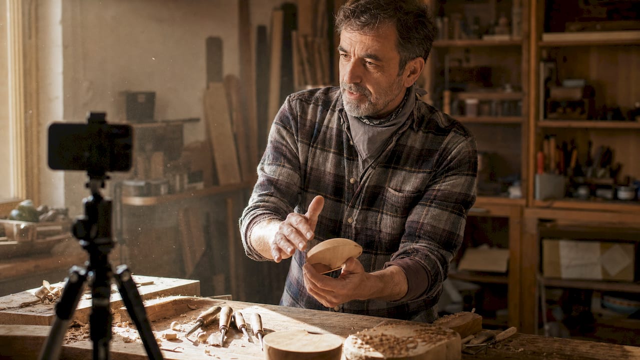 Un menuisier en train de tourner une vidéo pour présenter son atelier et partager son savoir-faire