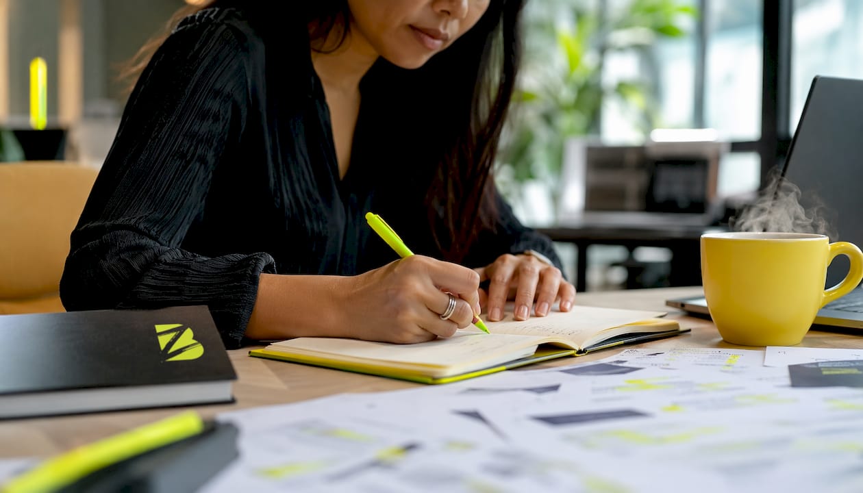 Des mains en train de taper sur un ordinateur portable, en train d’élaborer des listes de mots-clés pour des campagnes SEA.