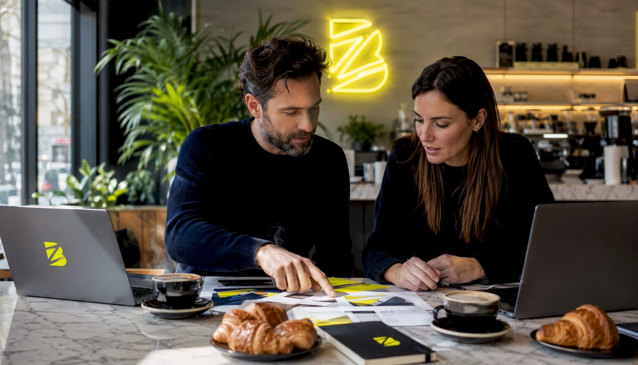 Deux spécialistes échangent autour des prestataires en image de marque dans un espace de coworking.
