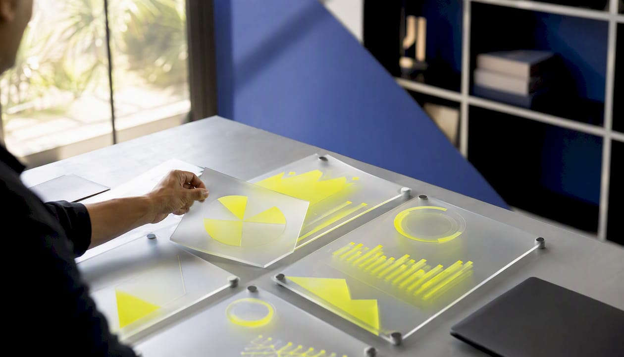 Une main manipule des tableaux de bord d’analyses aux couleurs vives
