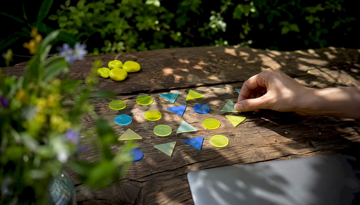 Une main dispose des marqueurs colorés sur une grille de planification hebdomadaire des contenus.