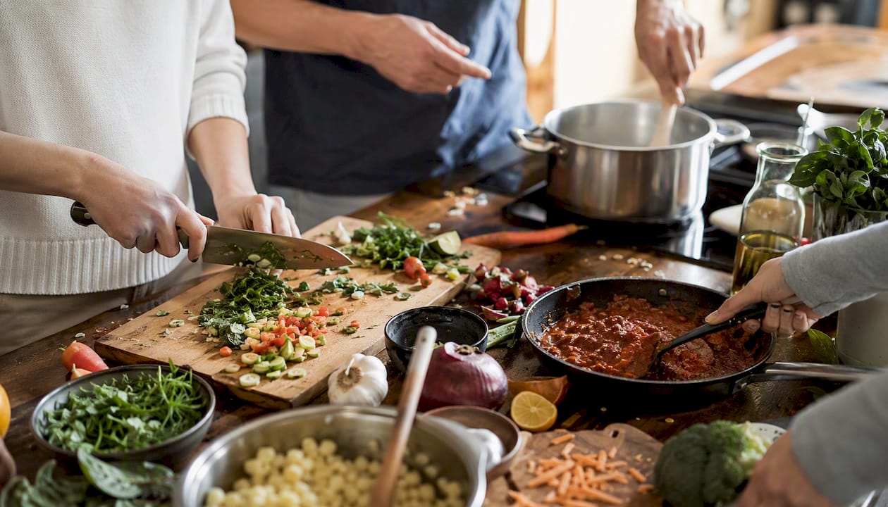Des équipes qui mettent la main à la pâte, coupent, émincent et cuisinent ensemble lors d’ateliers culinaires pour renforcer la cohésion.