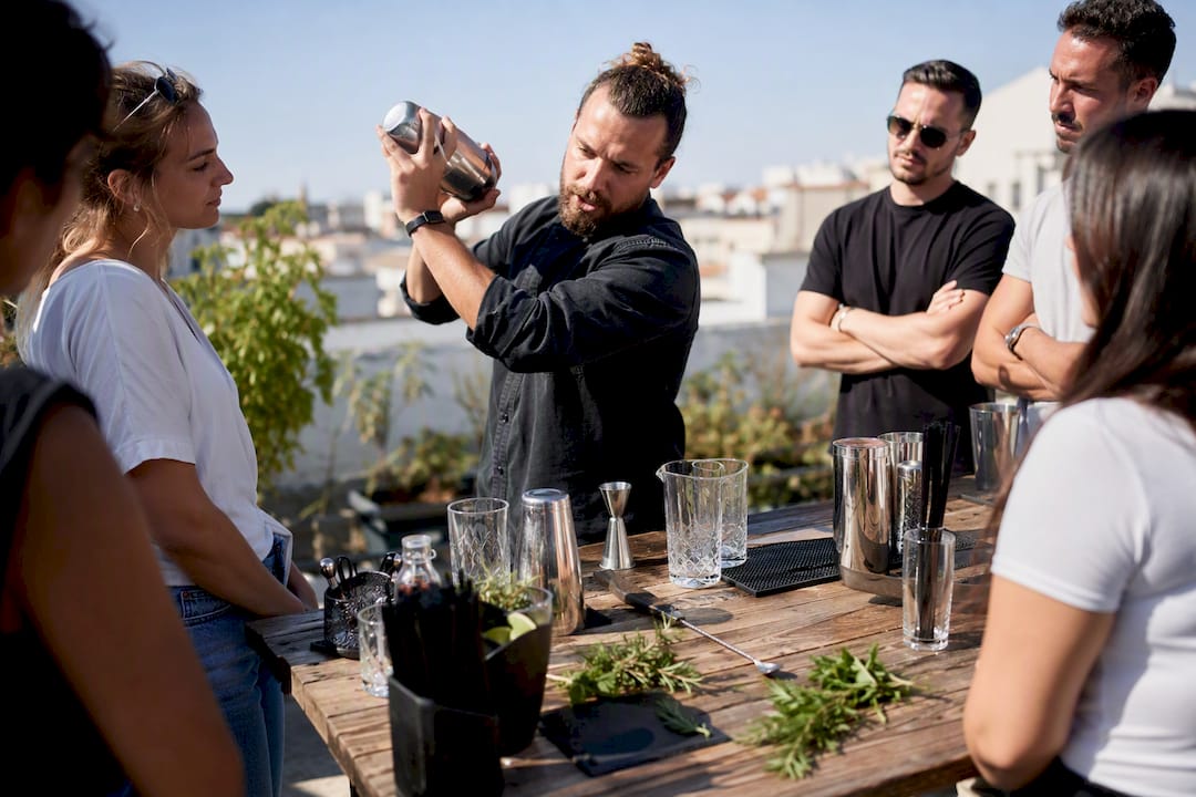 Un barman en pleine démonstration, en train de shaker un cocktail lors d’un atelier.