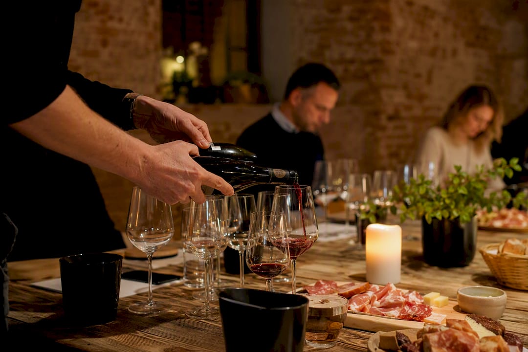 Des mains versant du vin lors d'un atelier dégustation