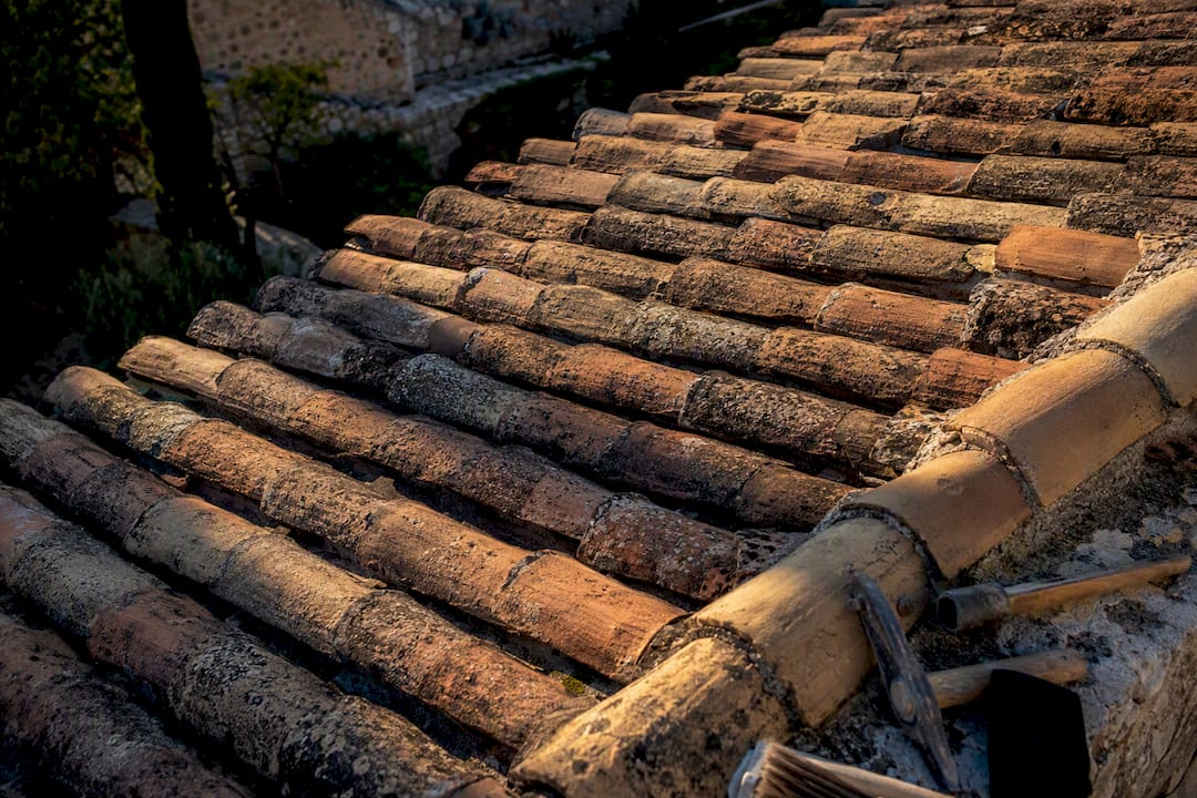 Tuiles anciennes fragiles sur une toiture historique