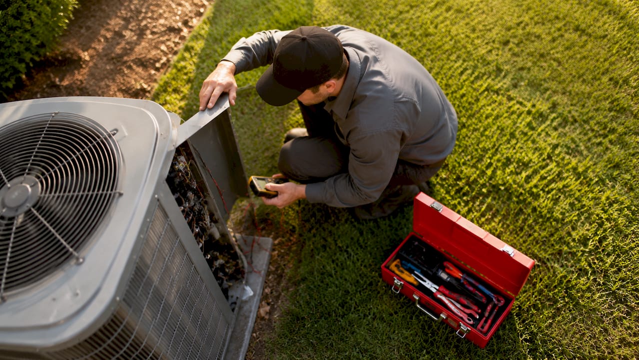 HVAC technician inspecting packaged unit outdoors
