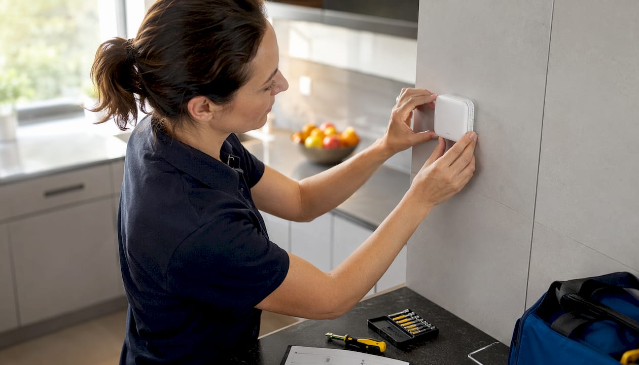 Technician installing room temperature sensor