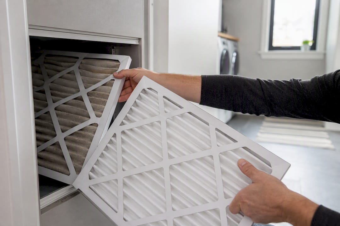 Hands replacing furnace air filter