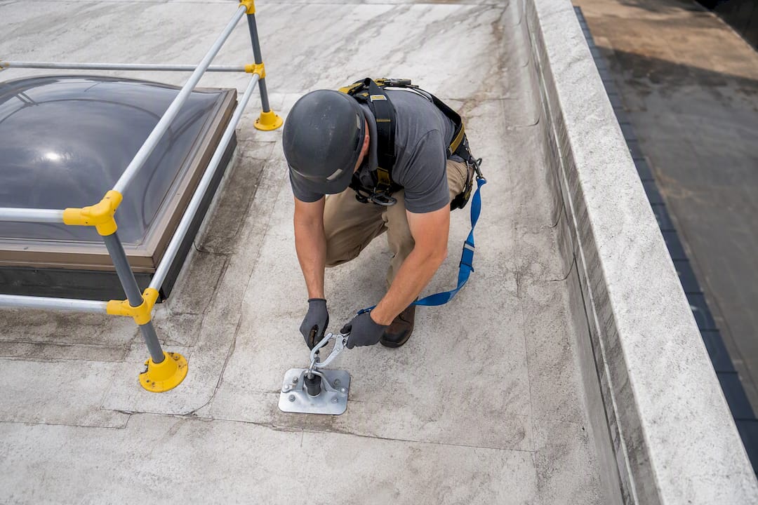 Technician securing rooftop fall protection