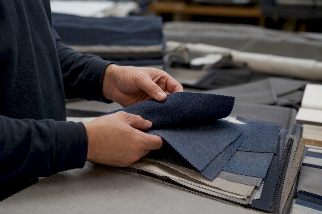 Hands inspecting textile fabric swatches