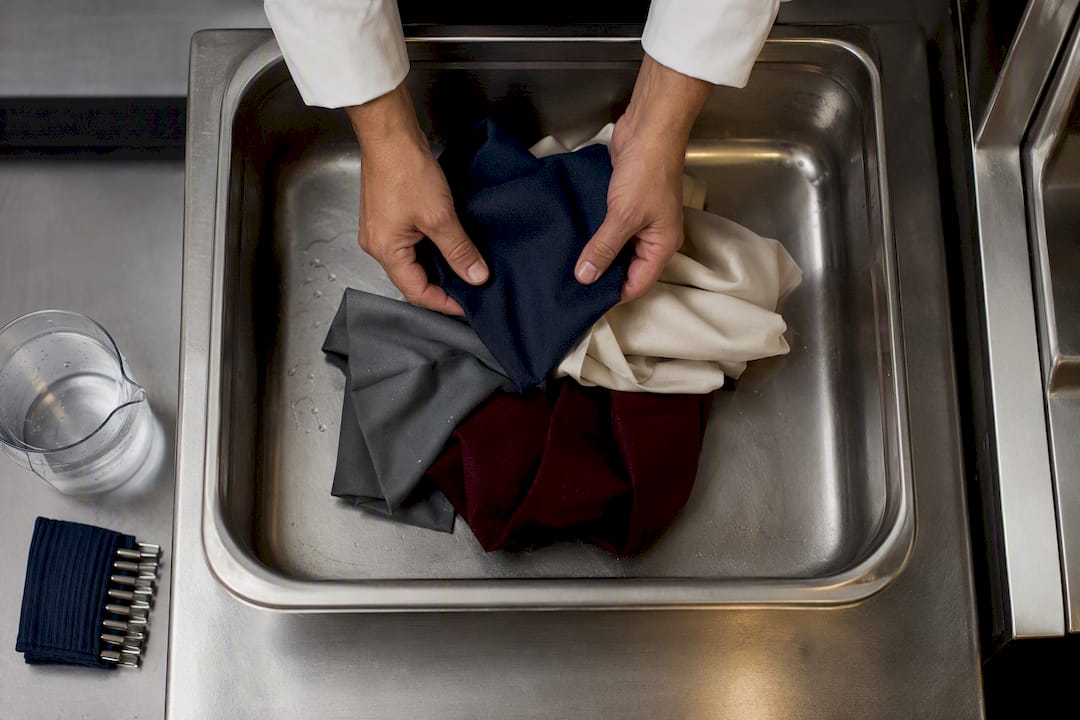 Hands preparing fabric samples for wash test