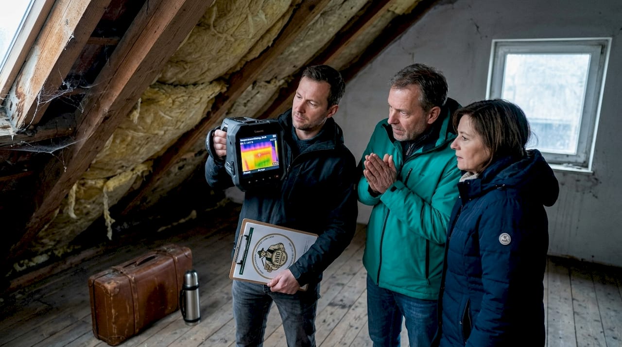 Ein Energieberater prüft das Dach mit einer Wärmebildkamera auf mögliche Wärmeverluste.