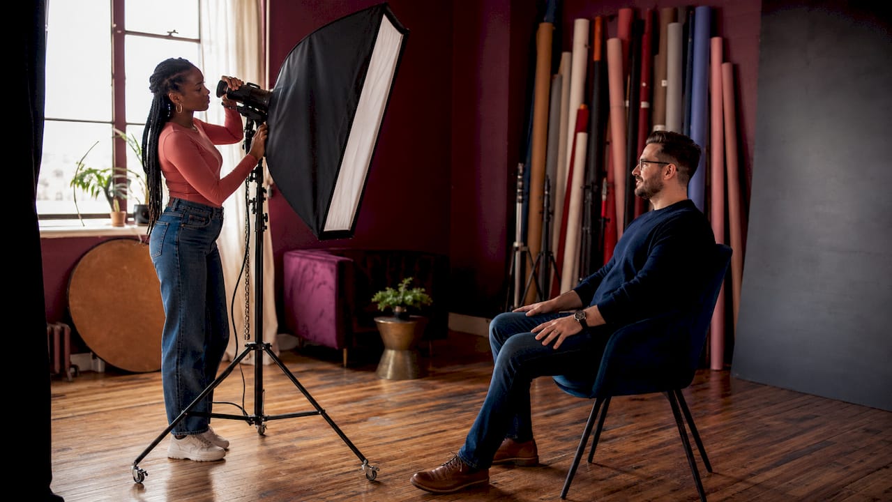 Photographer adjusting lighting for staff portrait session