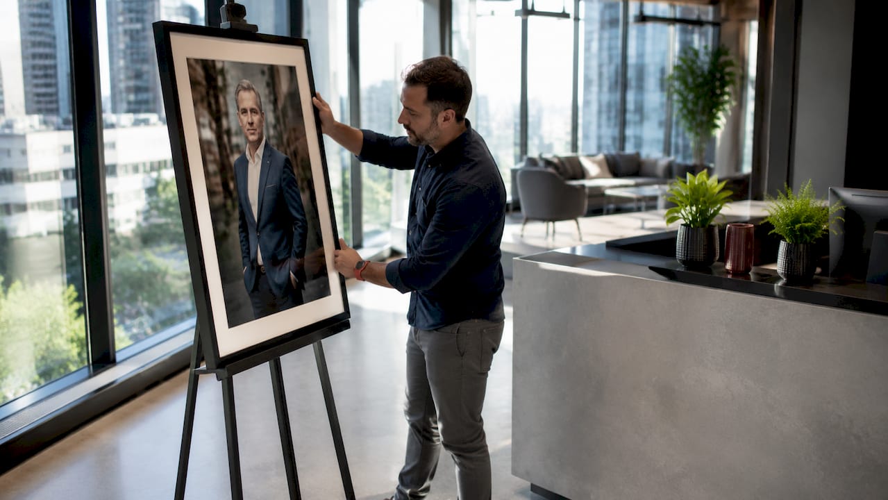 Photographer displaying corporate portrait in office reception