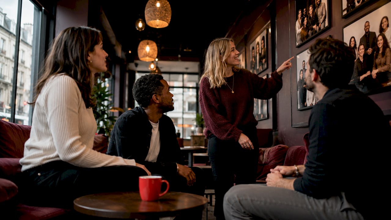Employees observing displayed team portraits in office lounge