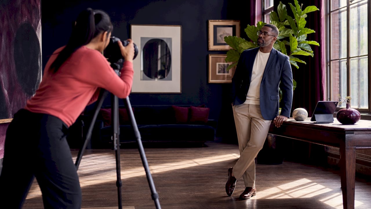 Photographer adjusting camera in office photoshoot