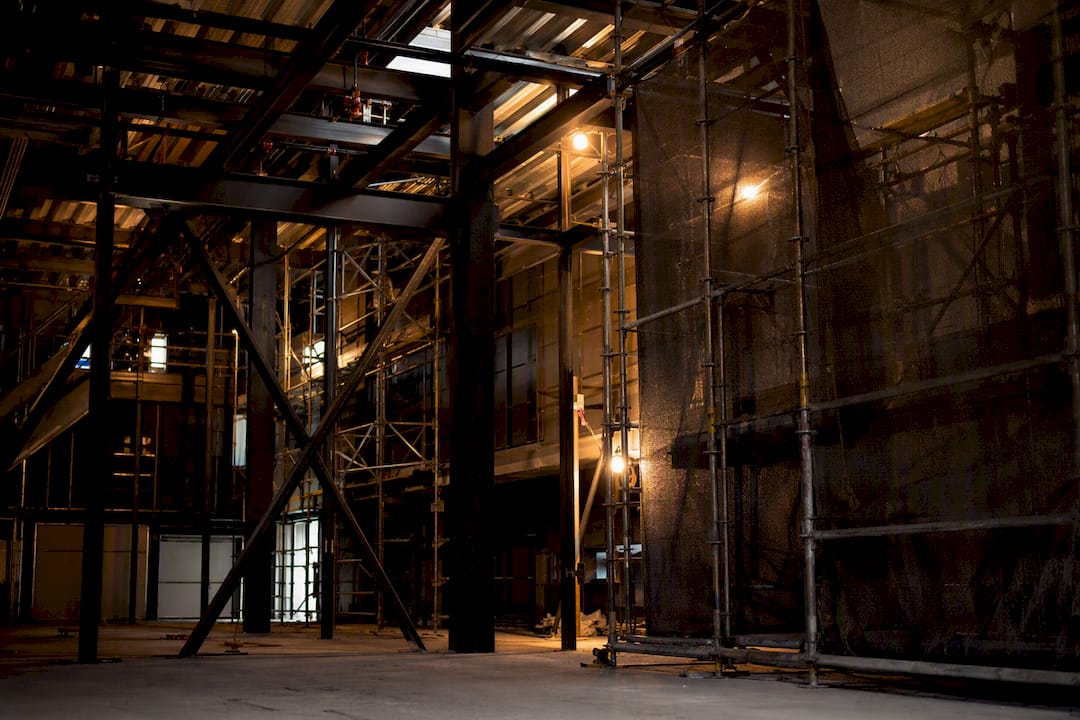 Steel beams and scaffolding under warm industrial light