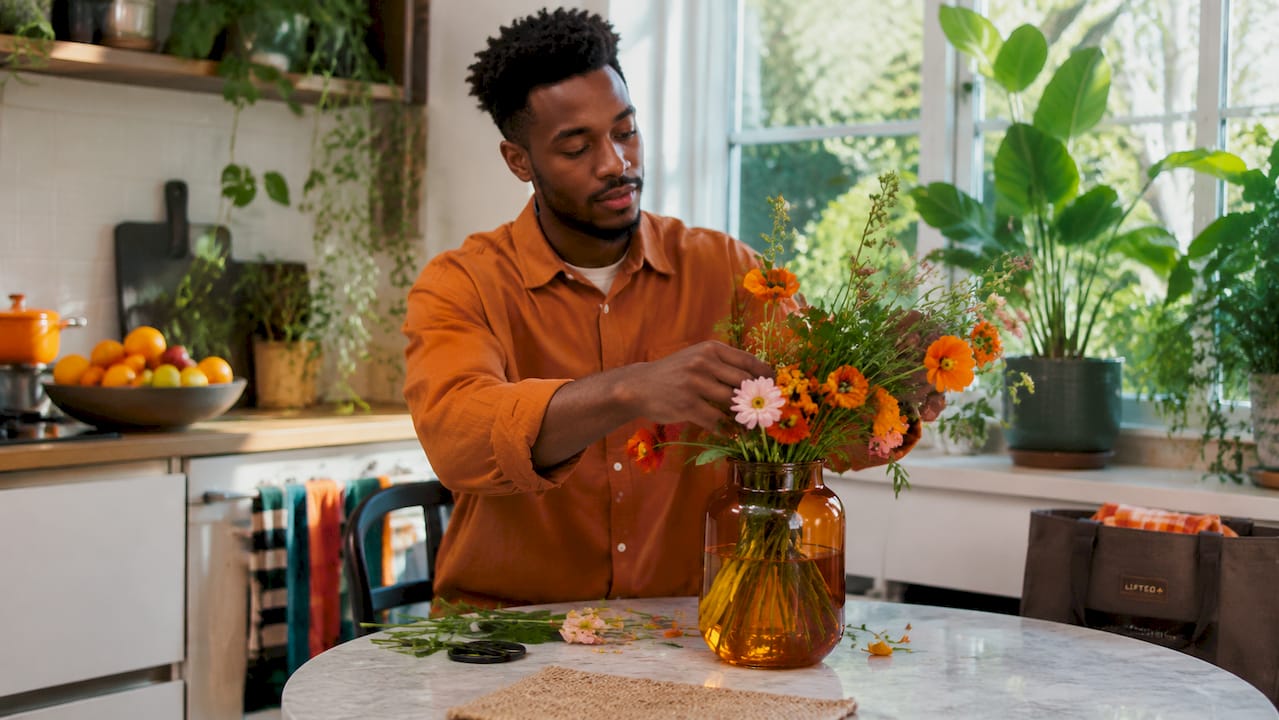 Why follow seasonal design trends for your home 2 Man arranging flowers in vase for mood wellbeing
