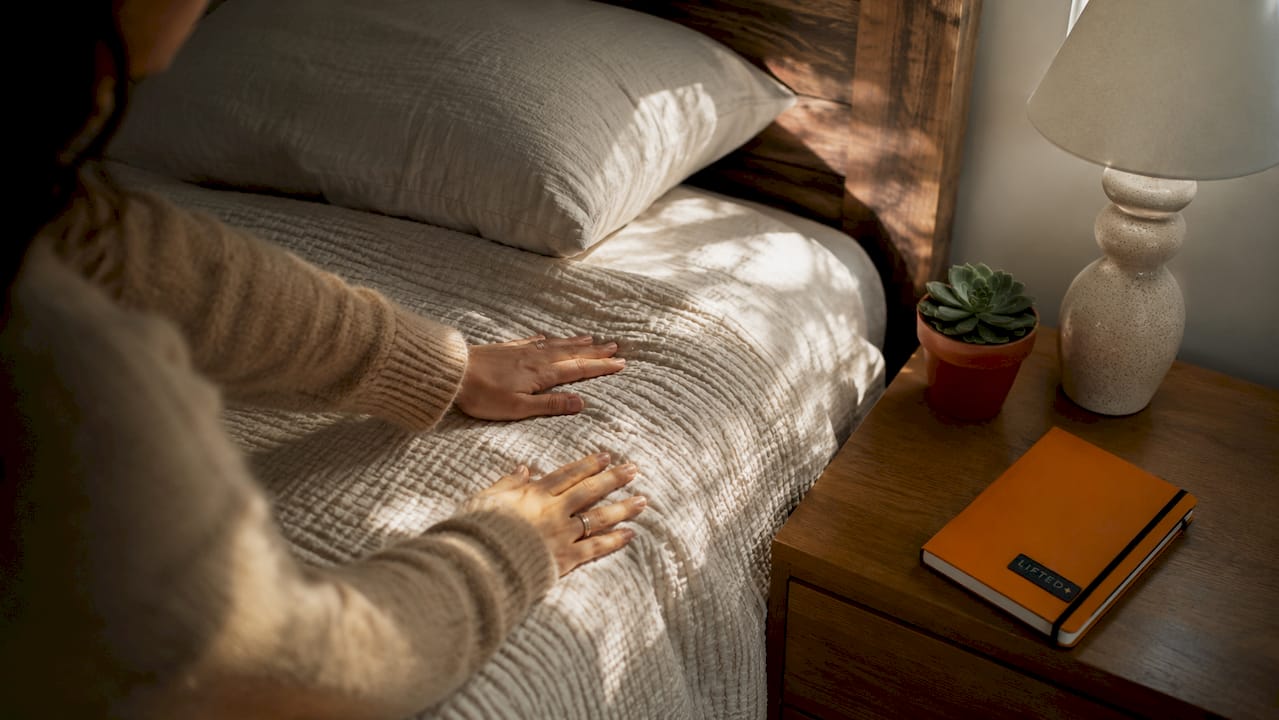 Emotional benefits of interior design for your home 3 Hands touching linen fabric on cozy bed
