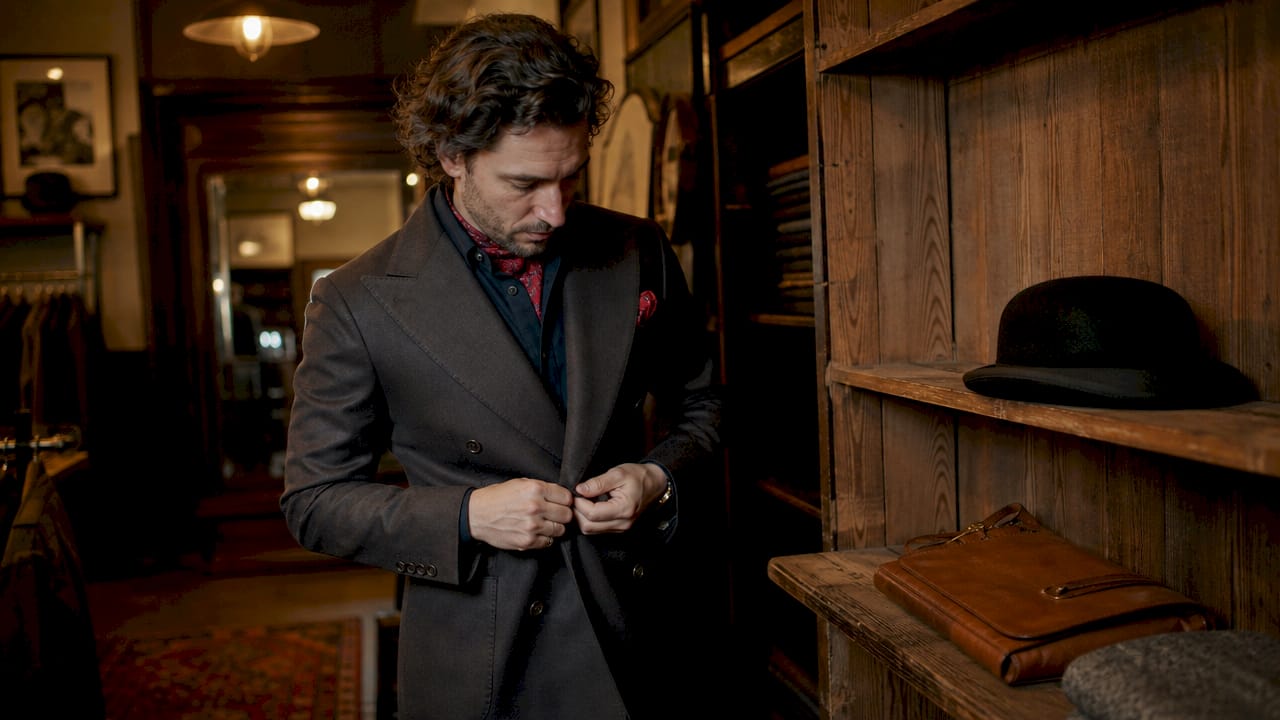 Man adjusting classic film-inspired tailored jacket silhouette