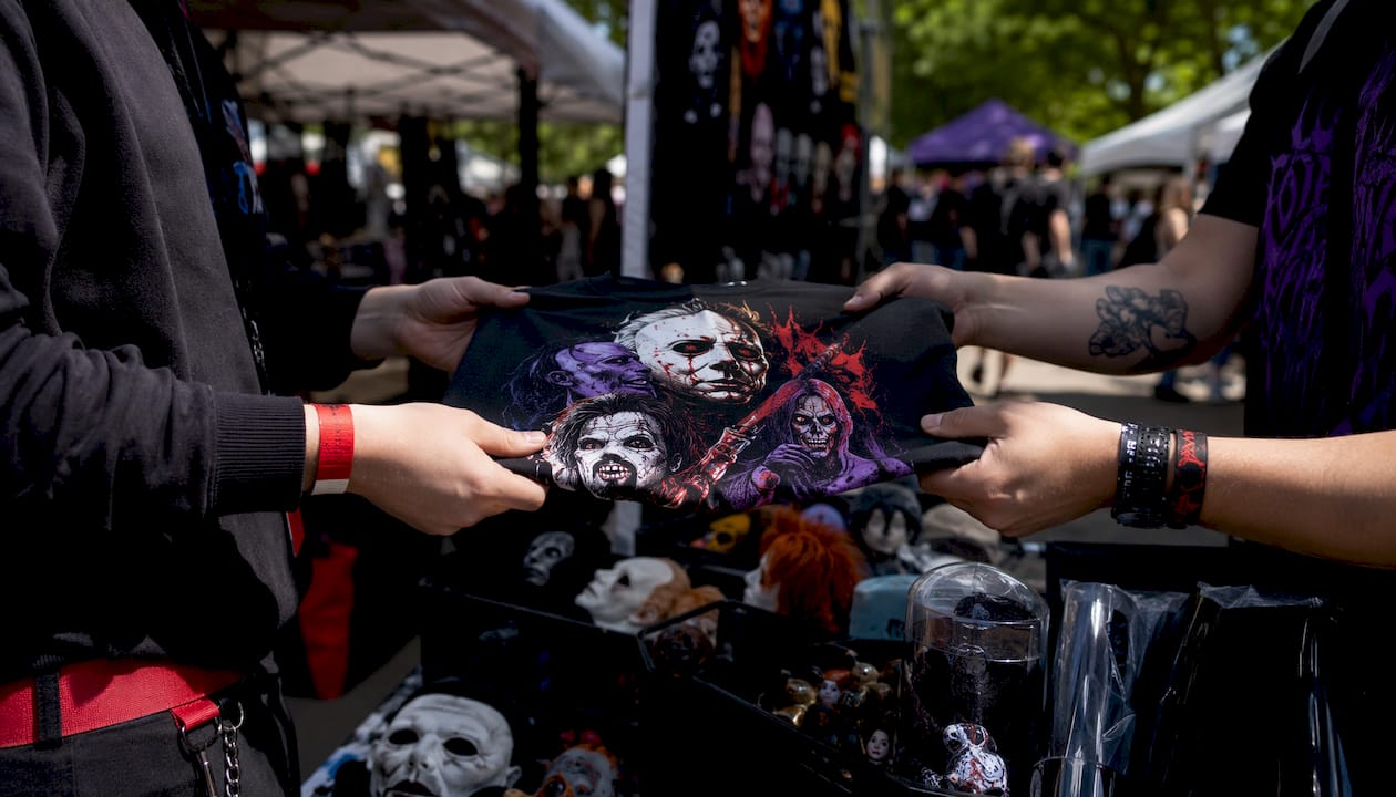 Hands exchanging horror graphic tee at fan event