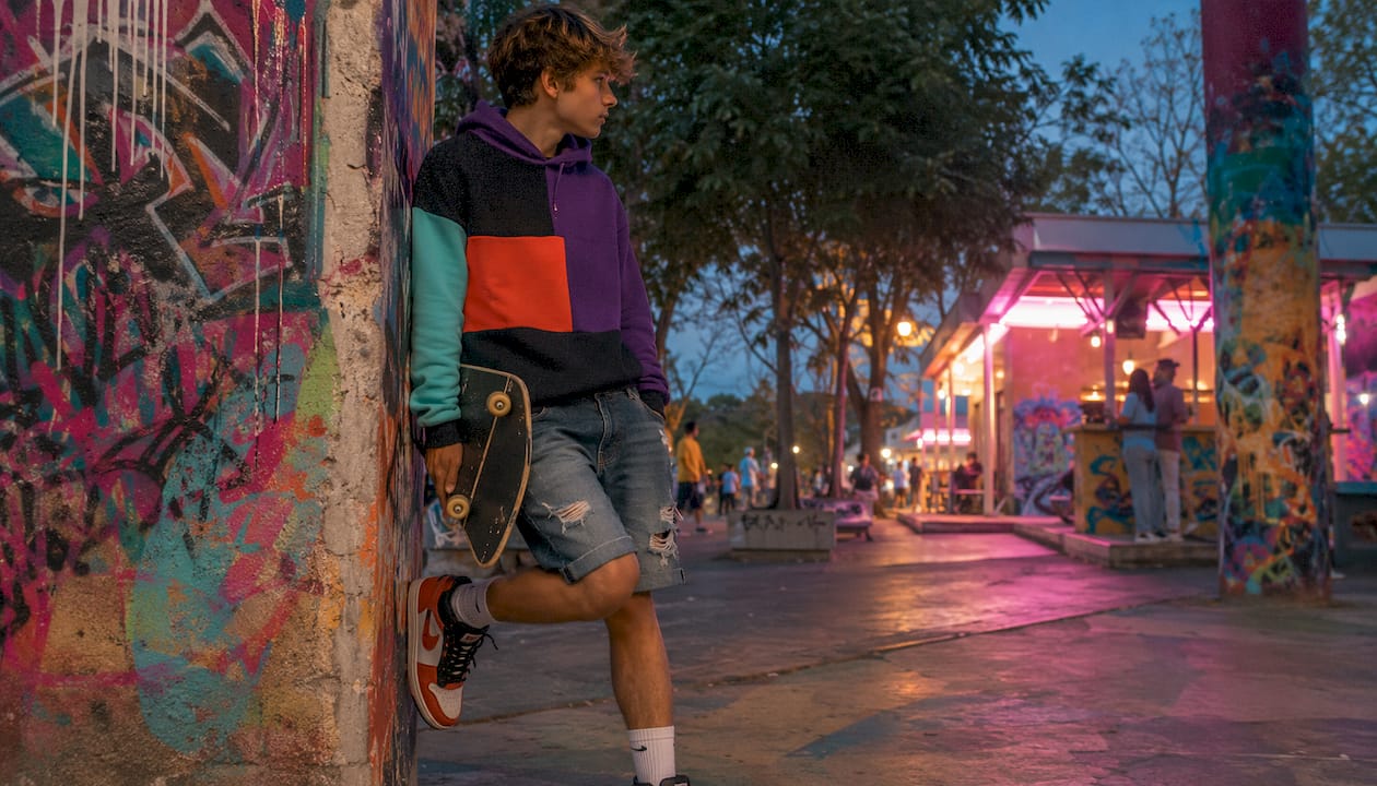 Teen boy in 80s style film hoodie on city street