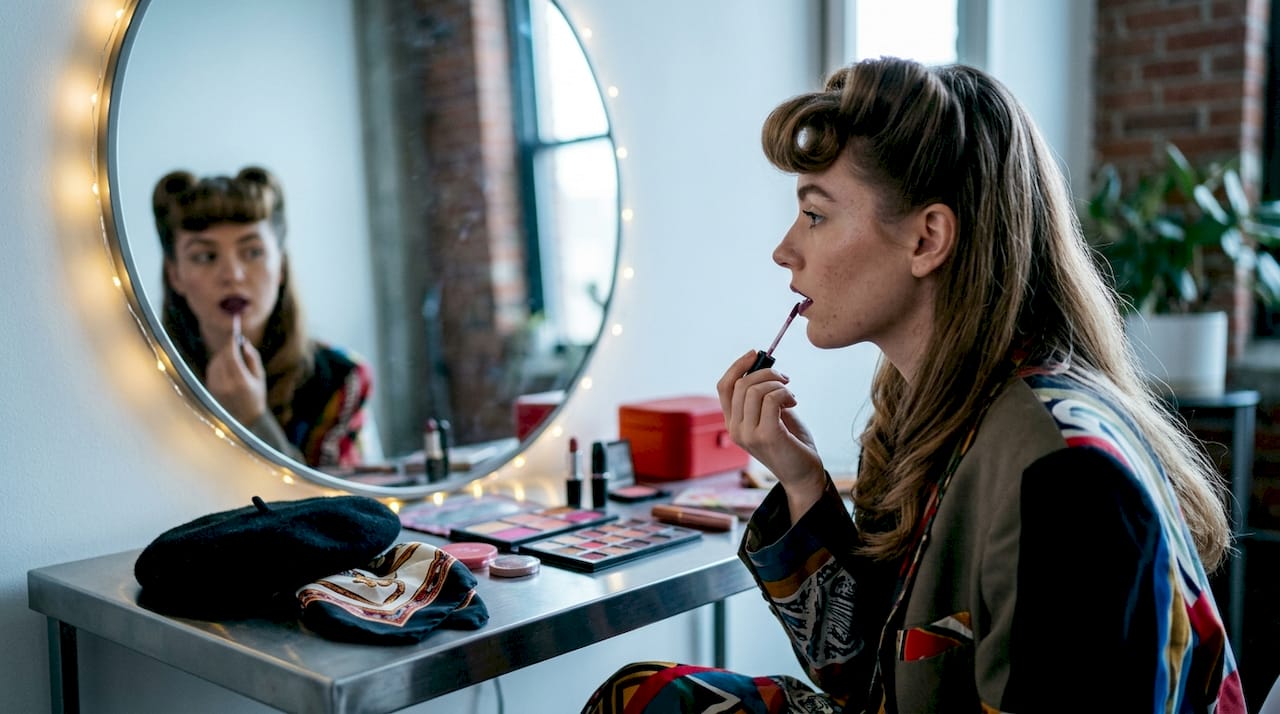 Woman styling vintage noir hairstyle and makeup
