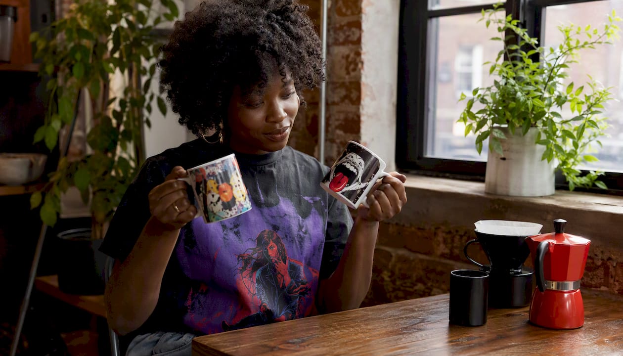 Hands comparing two funny coworker mugs