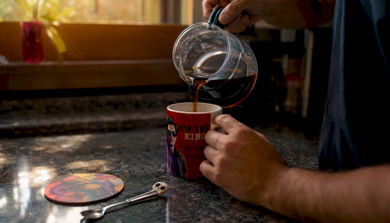 Hands pouring coffee into a movie-quote mug