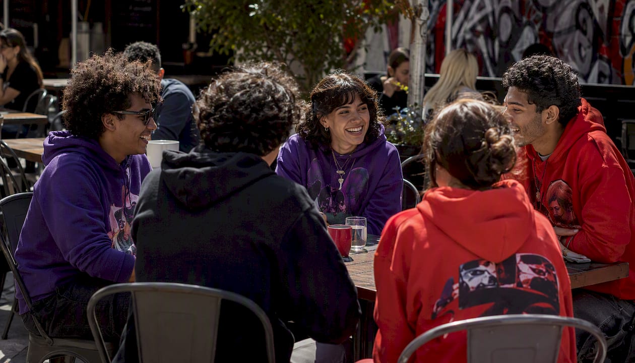 Young adults wearing ensemble film inspired hoodies outdoors