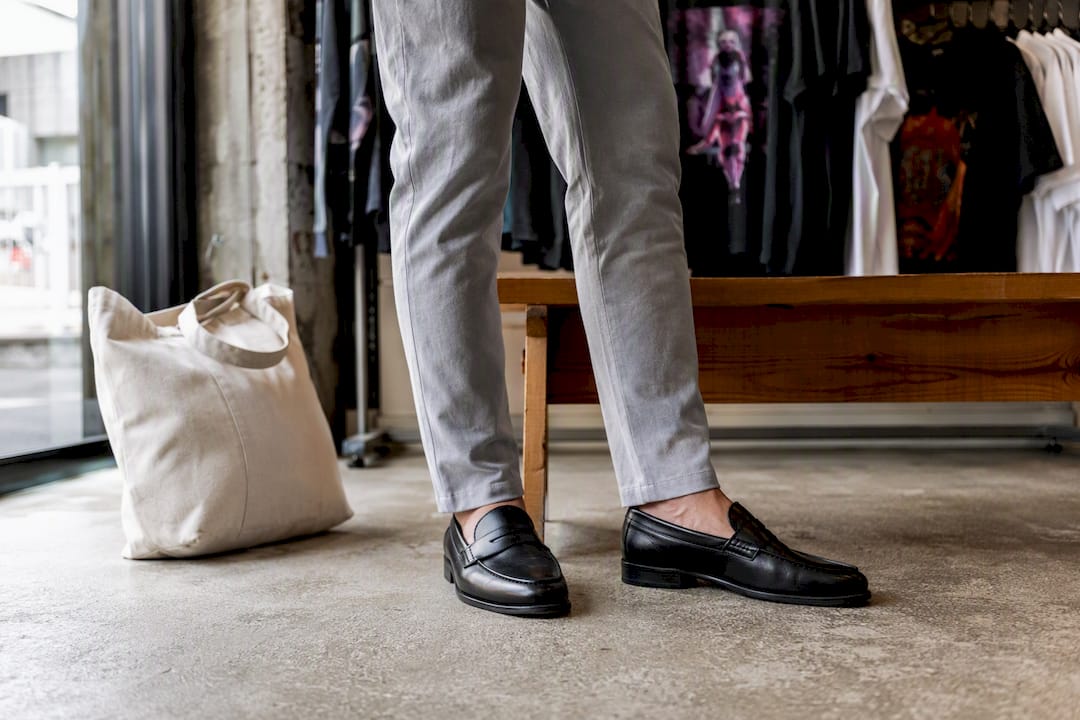 Chelsea boots with tailored pants and graphic tees behind