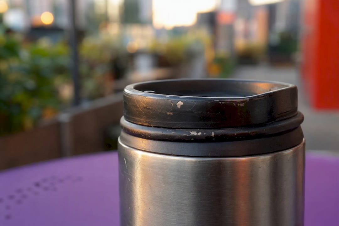 Worn stainless steel travel mug detail