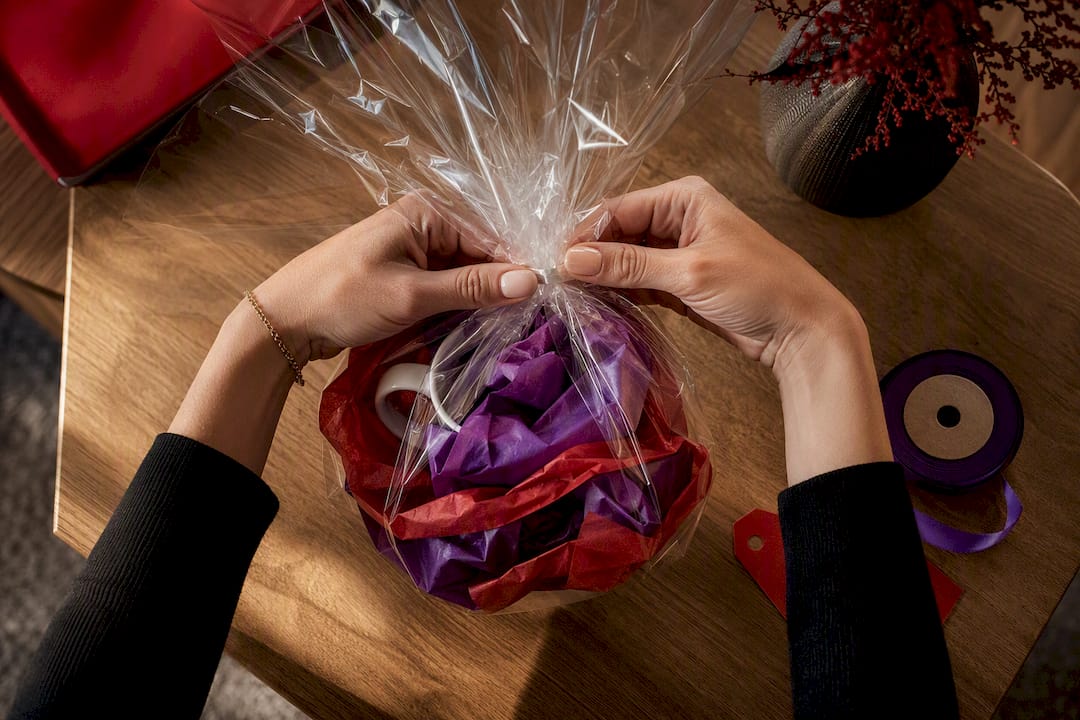 Cellophane gathered around a tissue-wrapped mug