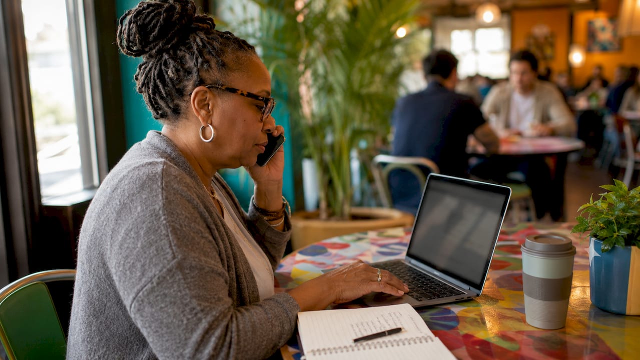 Woman making car insurance claim call at desk