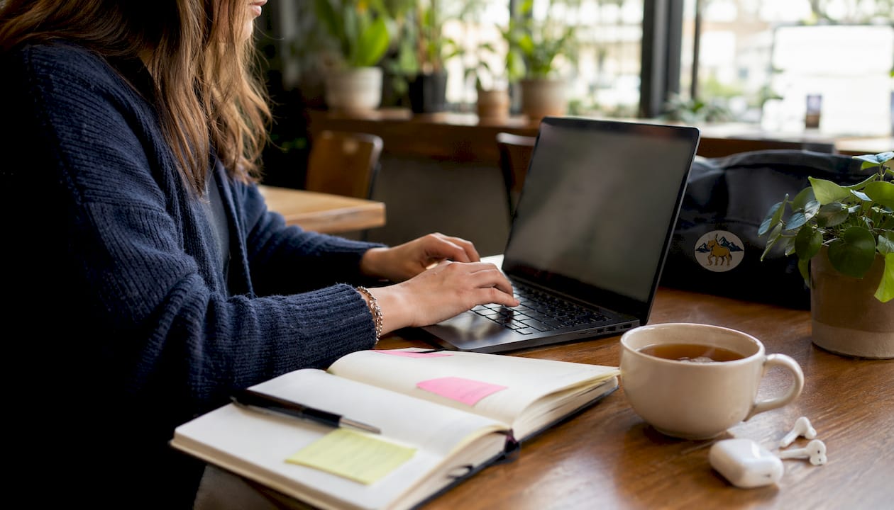 Hands typing insurance email on laptop keyboard