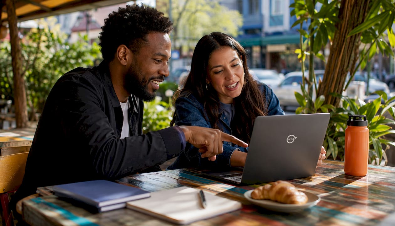 Friends filtering rental listings on laptop in cafe