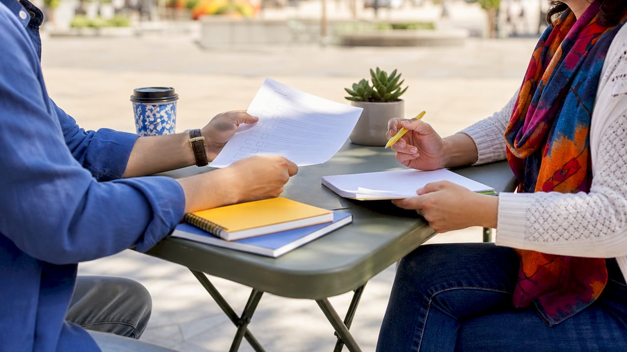 Close-up of team members reviewing Spanish communication checklist