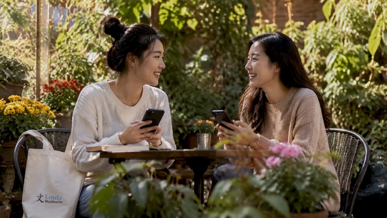 Two friends chatting in conversational Mandarin at café