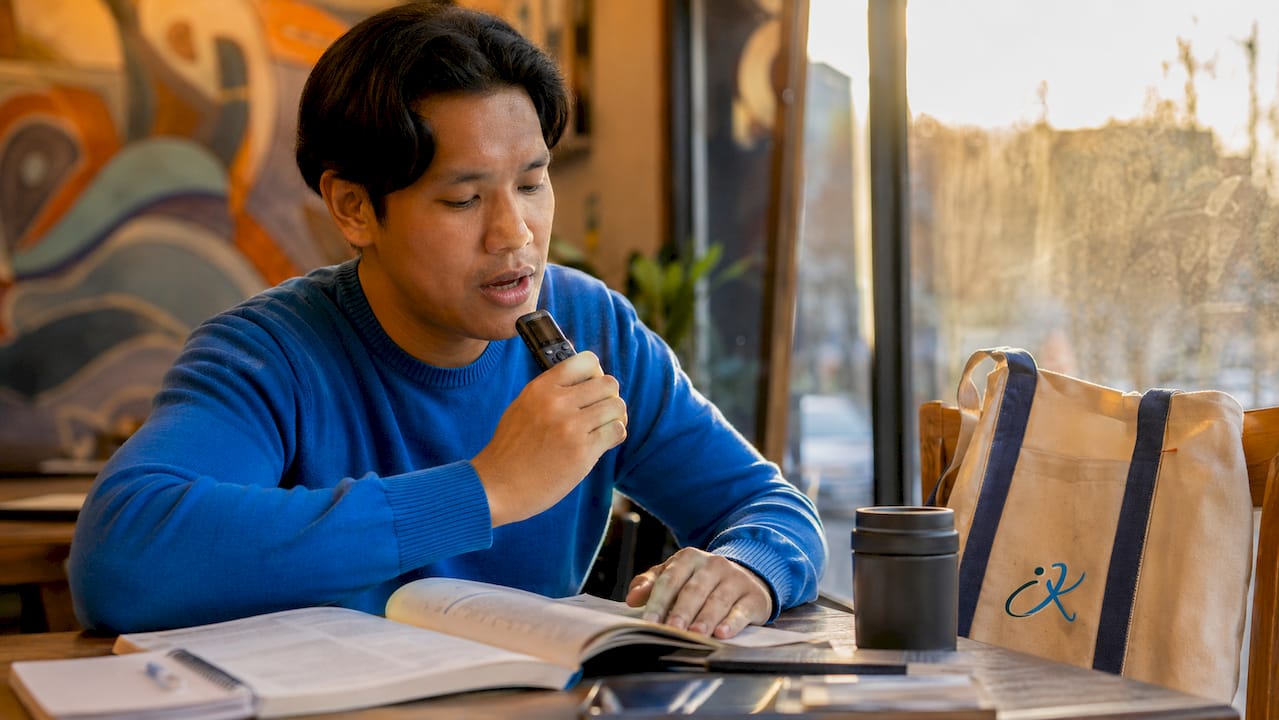 Man practicing Korean speaking skills with voice recorder