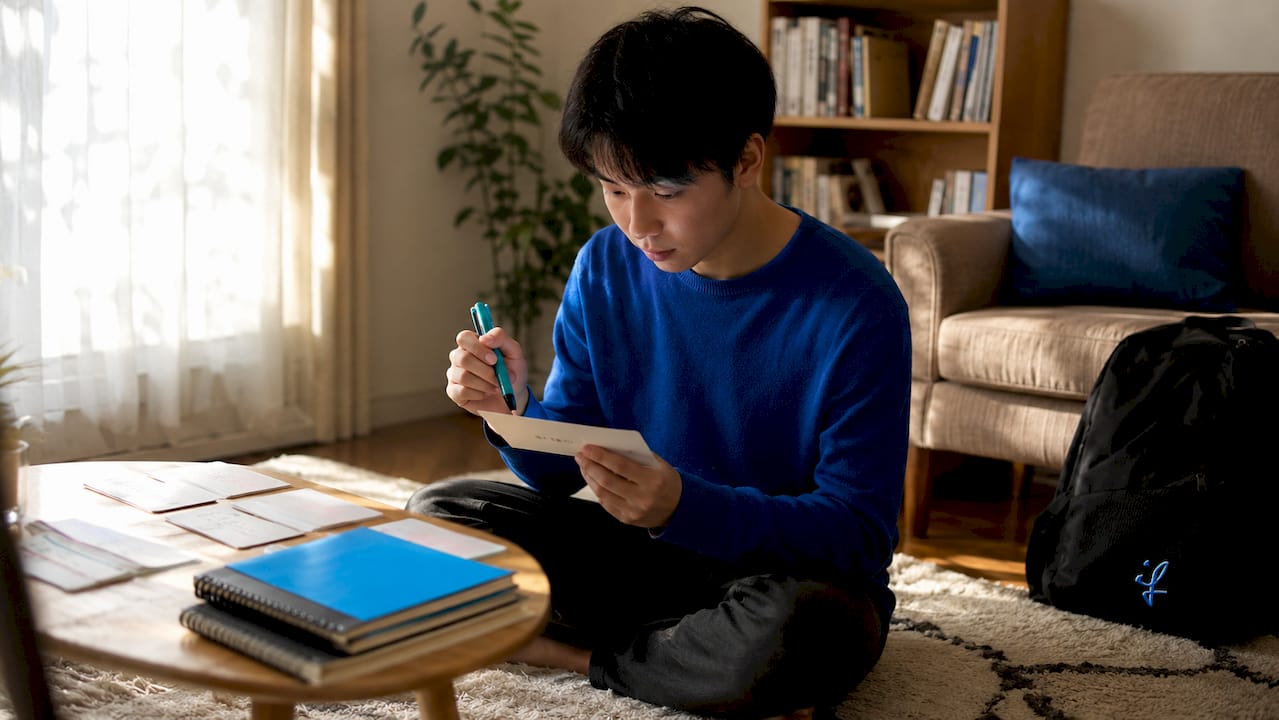 Hands practicing polite Japanese speech with flashcards