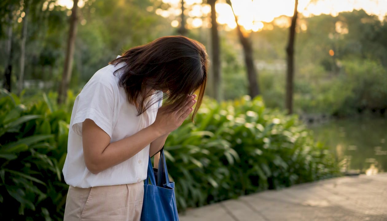 Person performing wai greeting gesture