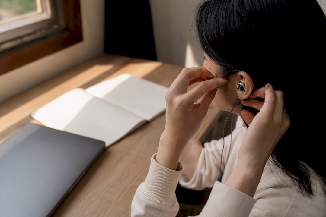 Hands adjusting earbuds for listening practice